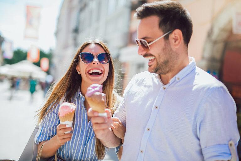Glückliches Paar, das sich nach dem Einkaufen verabredet und Eiscreme isst