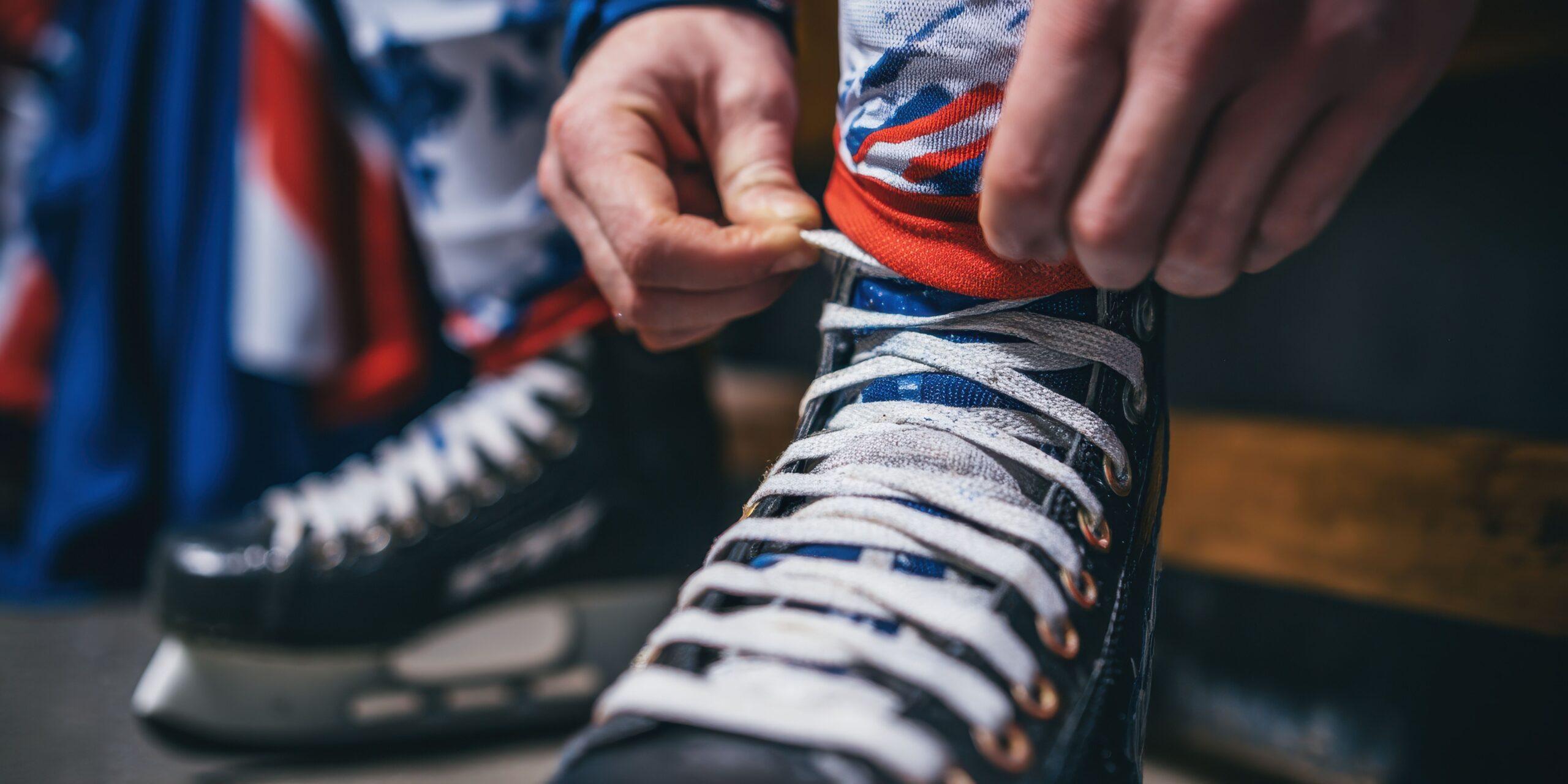 Detailaufnahme eines Hockeyspielers beim Schnüren von Schlittschuhe Bauer – Fokus auf Komfort, Passform und Polsterung
