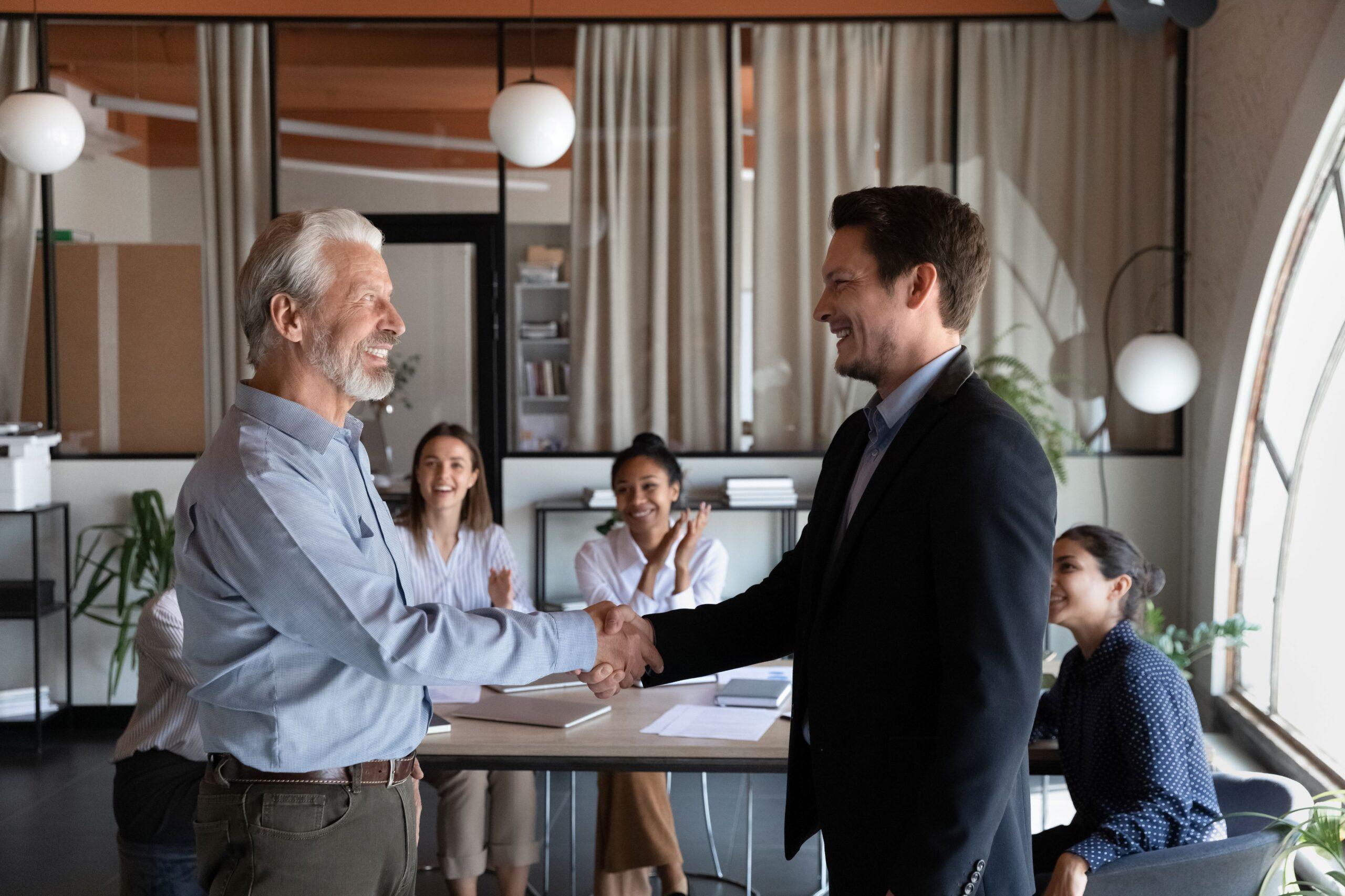 Medaille als Symbol für Anerkennung, zwei Personen reichen sich die Hand nach erfolgreicher Leistung, Zeichen für Wertschätzung
